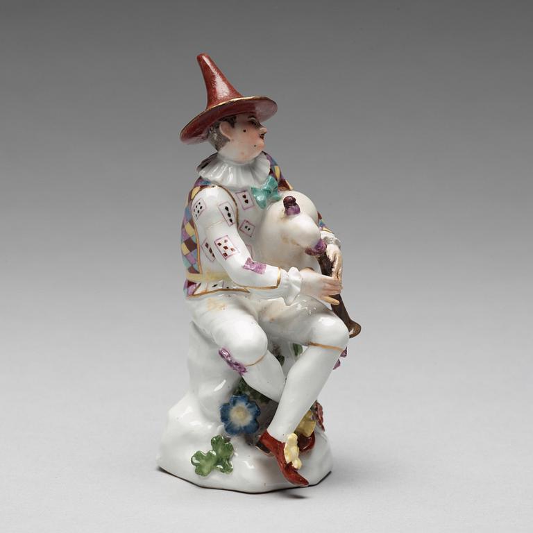 A porcelain figure of harlekin playing the bagpipe, circa 1900.