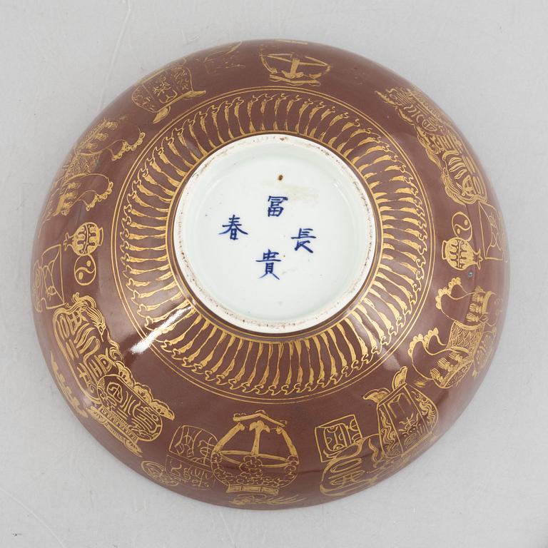 A brown glazed bowl with gilded decoration of animals and antiques, Qing dynasty, 19th century.