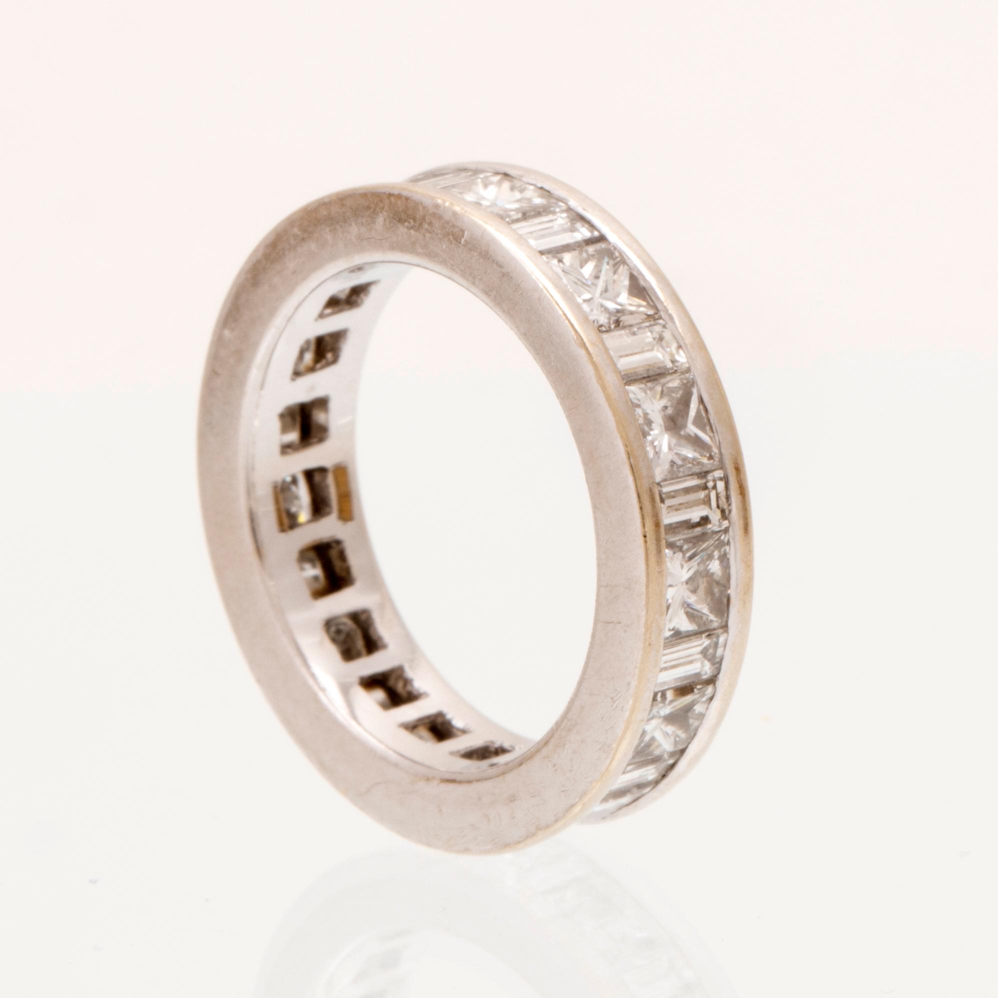 An 18K white gold eternity ring set with baguette and princess cut diamonds by Hartmann's Denmark.
