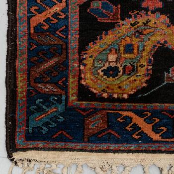 A RUG, an old Kurdish probably, ca 140,5-143,5 x 94,5-102 cm (as well as 2 cm flat weave at each end).