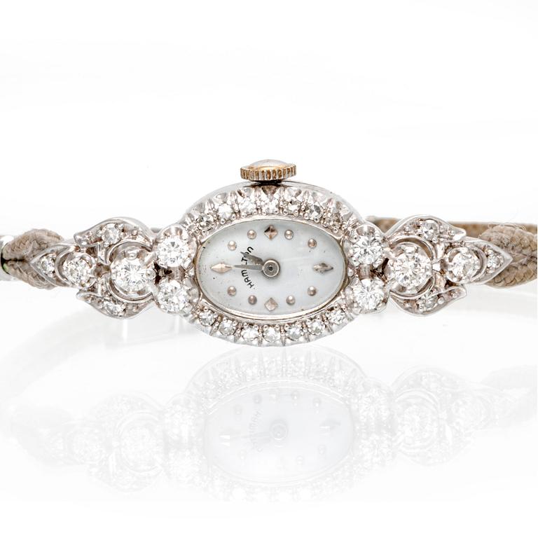 A 14K white gold wristwatch by Hamilton set with singe cut and round brilliant cut diamonds.
