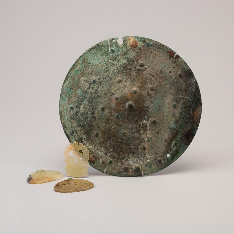 Three 20th century stone objects, with one bronze shield.