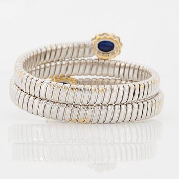 An 18K gold bangle set with cabochon-cut sapphires and round brilliant-cut diamonds.