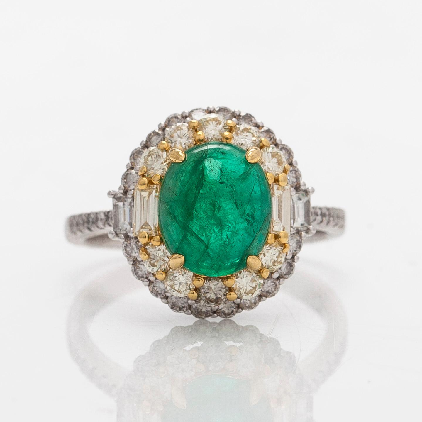 An 18K whitegold ring set with a cabochon-cut emerald and baguette- and brilliant-cut diamonds.