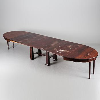 A late 19th century dining table with ten chairs and five extension leaves.