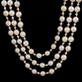A three strand cultured pearl necklace with a clasp decorated with diamands.