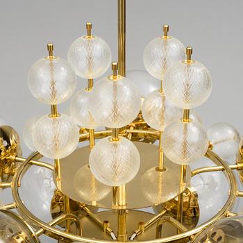 A 1970s brass ceiling light with glass shade. Height ca 144.