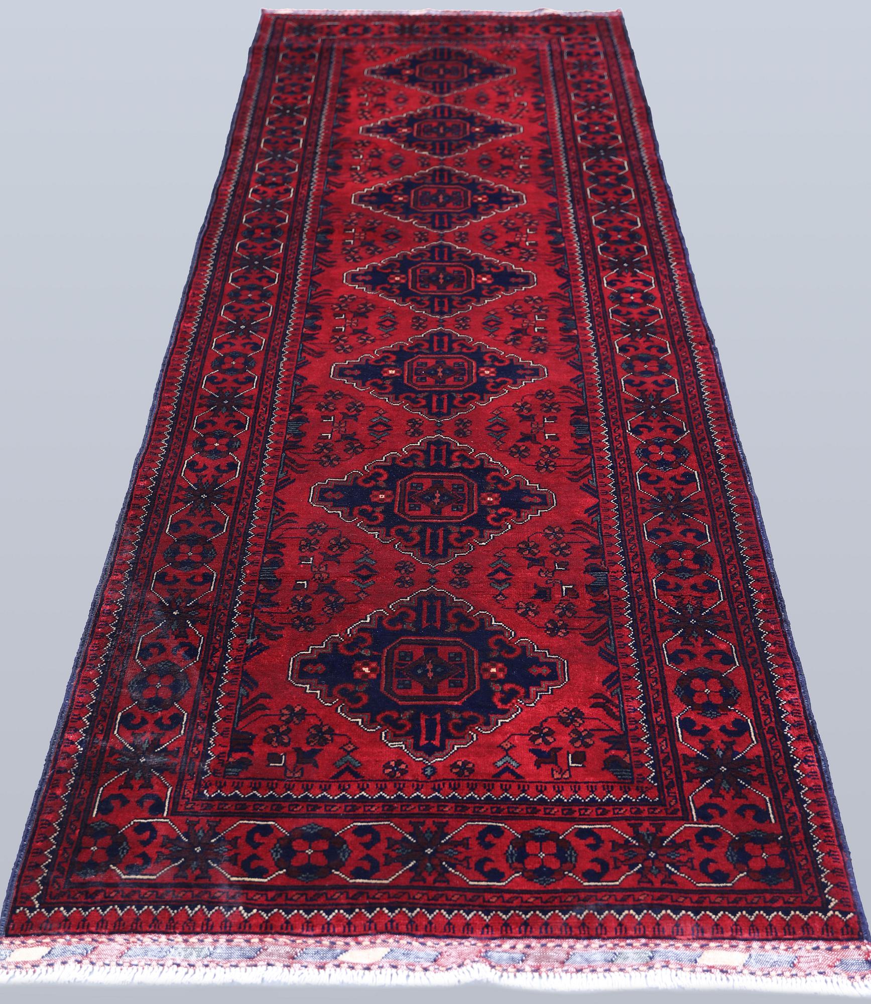 An Afghan runner, approximately 283 x 87 cm.