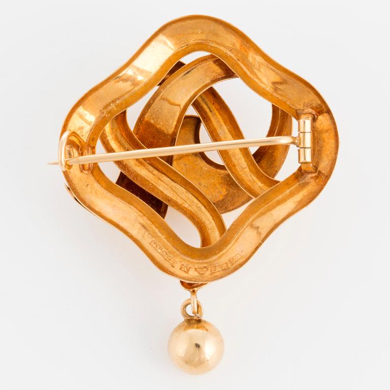 An 18K gold brooch.