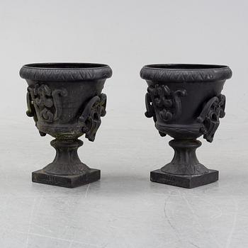 A pair of cast iron garden urns, Norrtälje dated 1989.