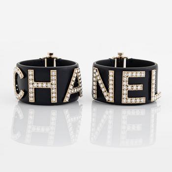 Chanel, a pair of black leather and rhinestone bracelets.