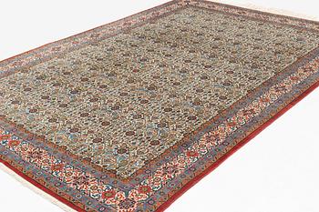 A carpet, semi-antique, Qum, ca 324 x 221 cm.