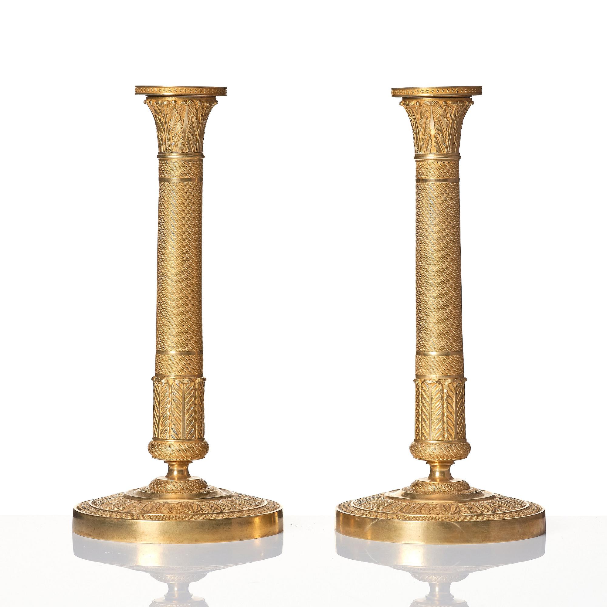 A pair of French Empire ormolu candlesticks, early 19th century.