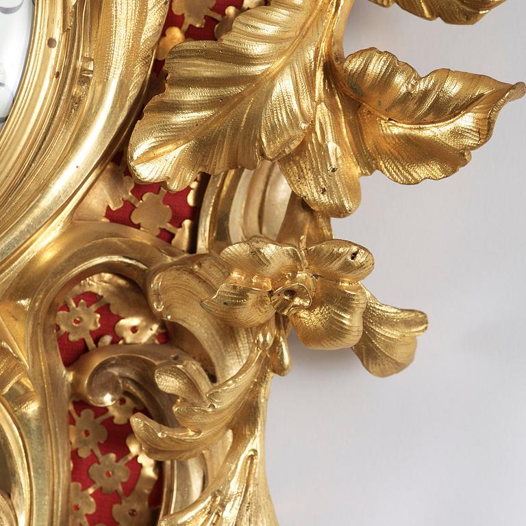 A Louis XV-style 19th century gilt bronze wall clock. Clockwork by W. M. Blakey, master in Paris 1755-74.