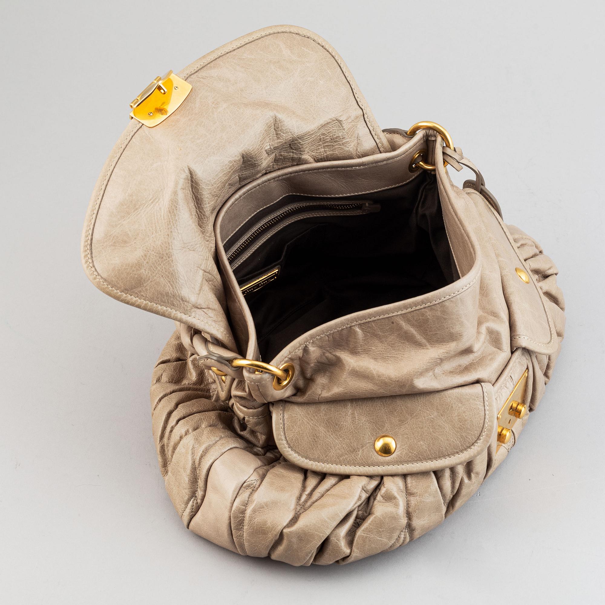 Miu Miu, a light leather handbag.