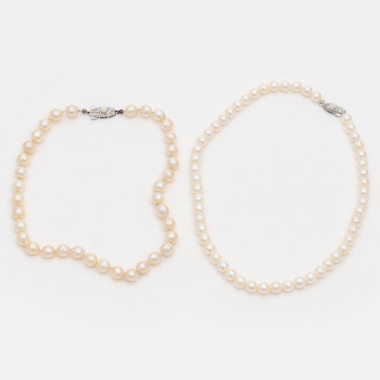 Two cultured pearl necklaces with silver clasps.