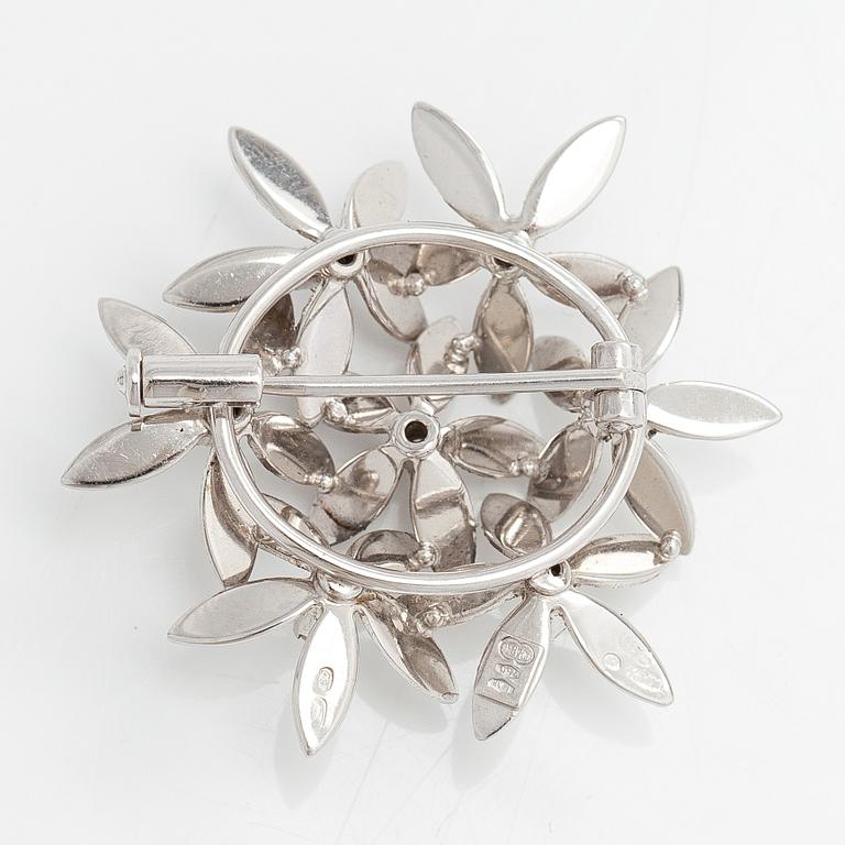 An 18K white gold brooch with diamonds ca. 0.10 ct in total. Unoarre, Italy.