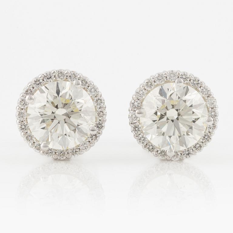 A pair of 18K gold earrings with round brilliant-cut diamonds.