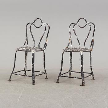 a pair of modern iron graden chairs,