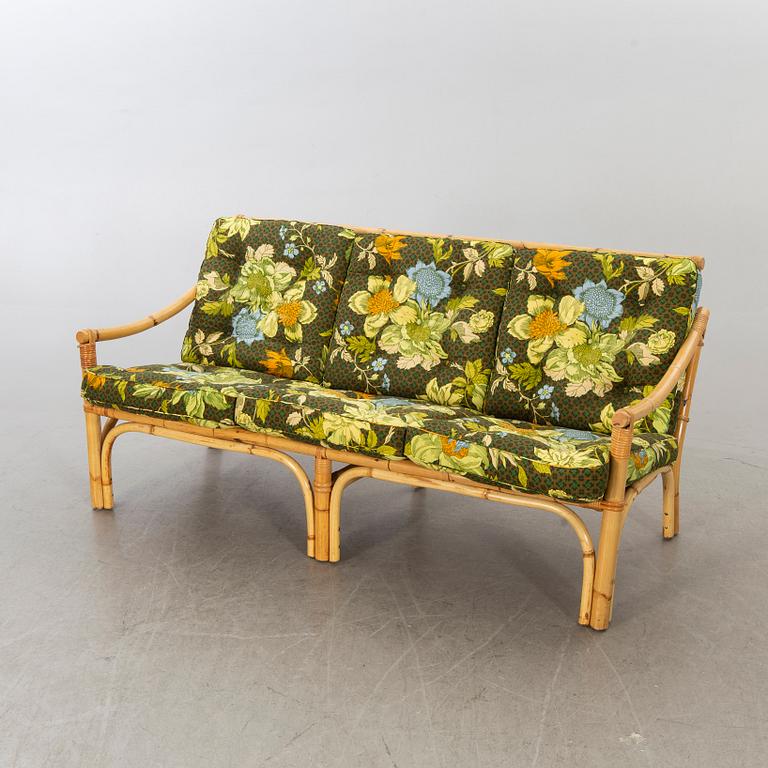 A set of ratten furniture, late 20th century; sofa, armchairs and a lounge table.