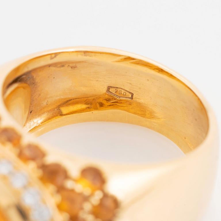 An 18K gold ring set with a cabochon-cut citrine and round brilliant-cut diamonds och citrines.