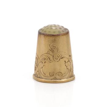 An 18K gold thimble.