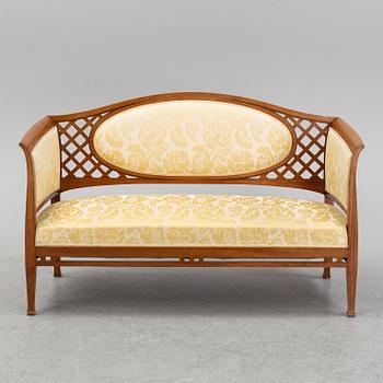 A mahogany sofa, with two armchairs and a round table, early 20th Century.