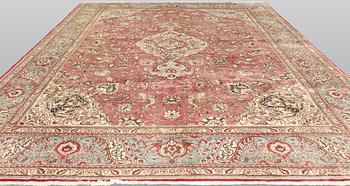 A Tabriz carpet, signed, c. 395 x 298 cm.