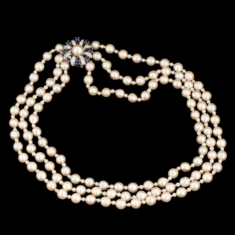 A necklace of baroque-shaped, cultured pearls with a clasp in 18K white gold decorated with diamonds and sapphires.