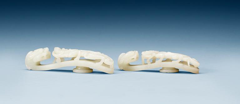 Two pale green nephrite garment hooks, Qing dynasty.