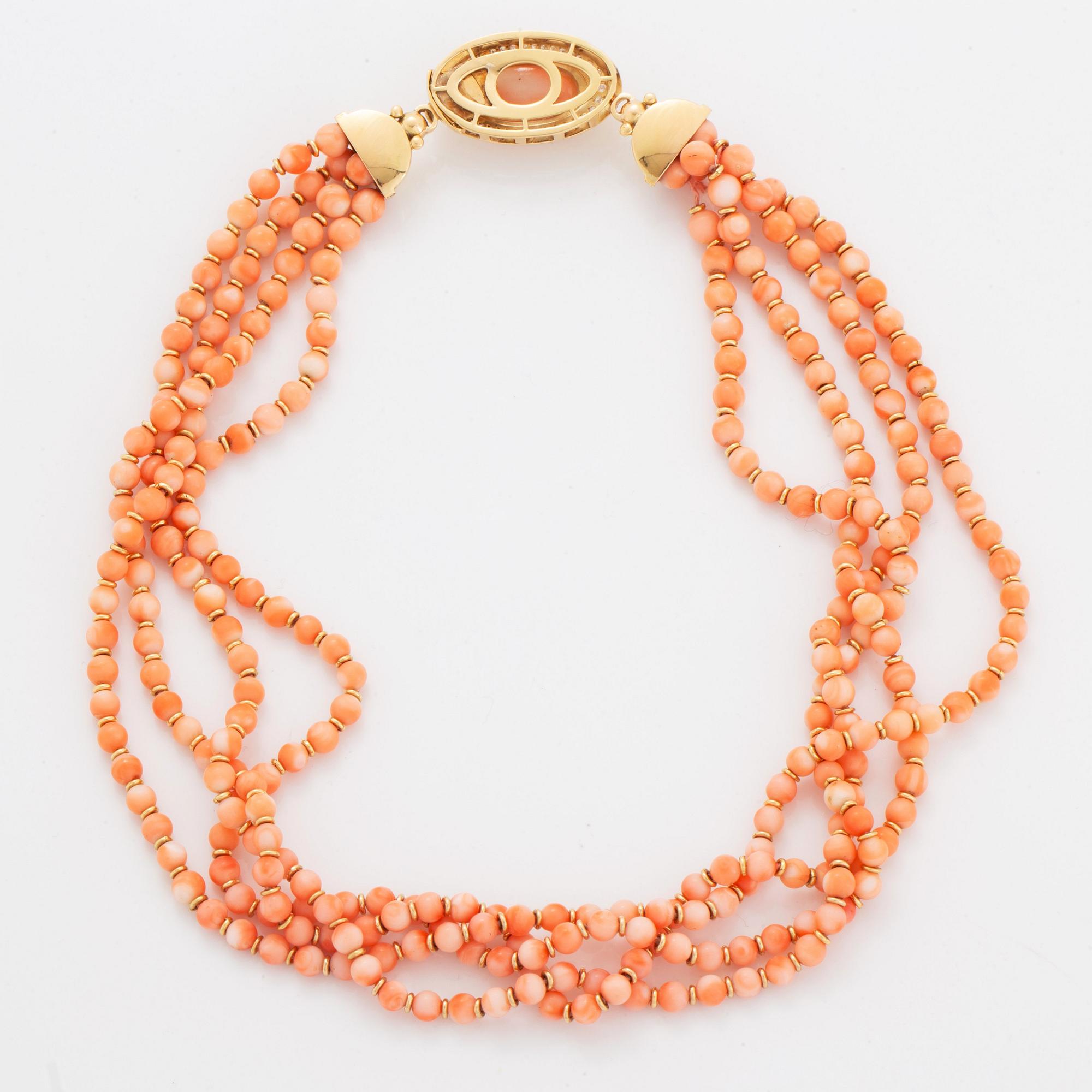 A four strand coral necklace with an 18K gold clasp set with coral and round brilliant-cut diamonds.