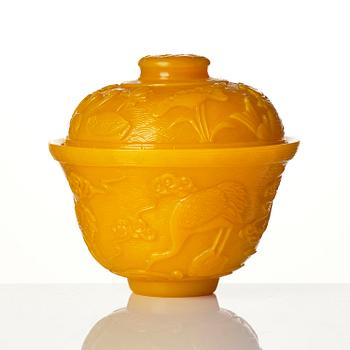 A well carved yellow glass 'crane and lotus' cup with cover, presumably late Qing dynasty.