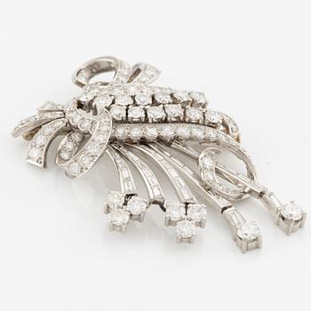 A platinum brooch with round brilliant and baguette-cut diamonds.