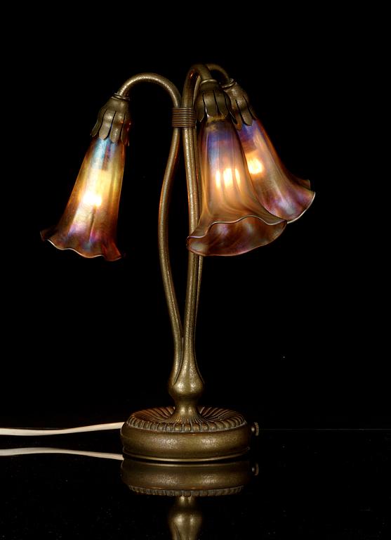 A Tiffany Studios 'Three Lily' lamp with a bronze base, New York circa 1910.