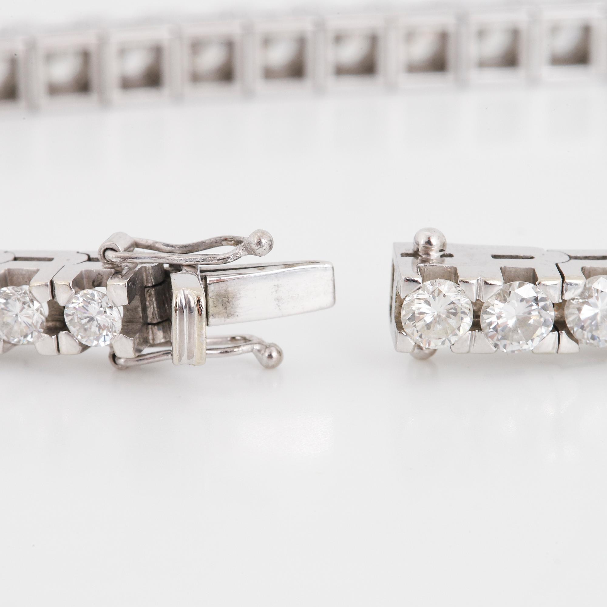 An 18K white gold tennisbraclet set with round brilliant-cut diamonds.