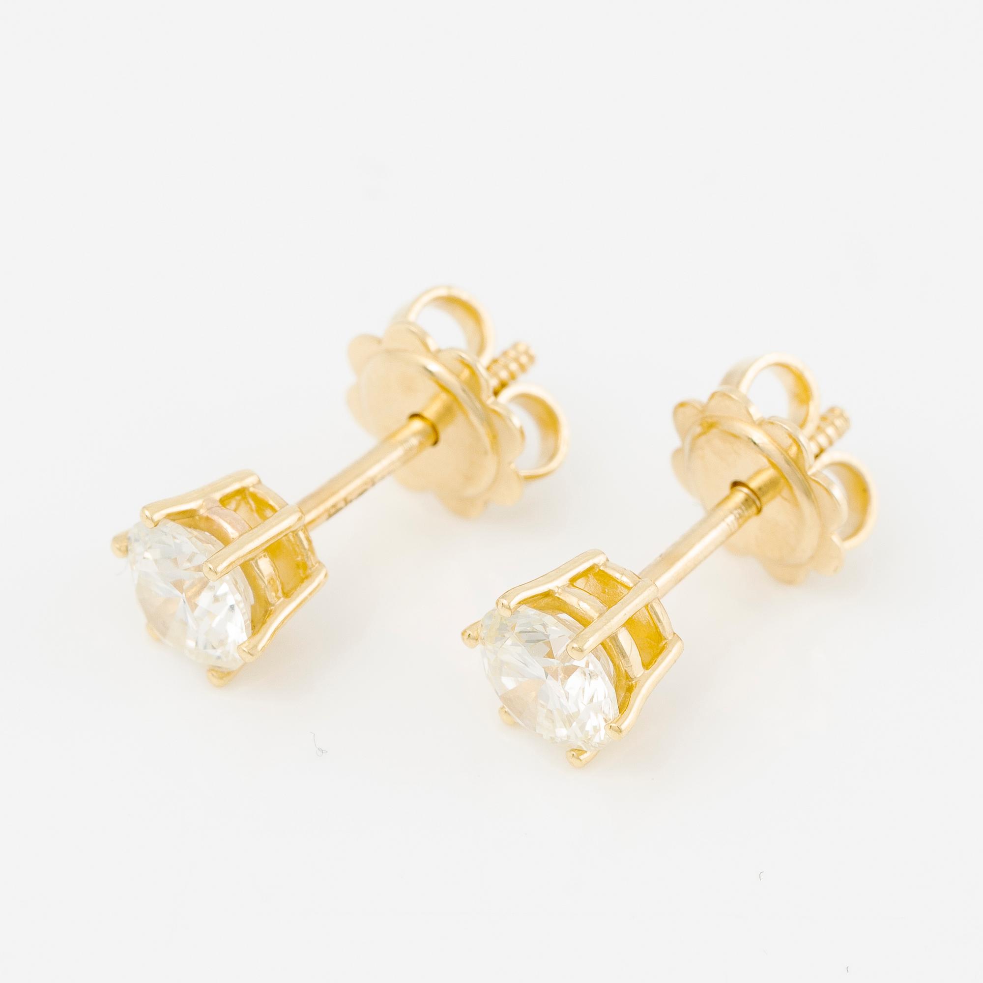 A pair of earrings in 18K gold set with two round brilliant-cut diamonds.