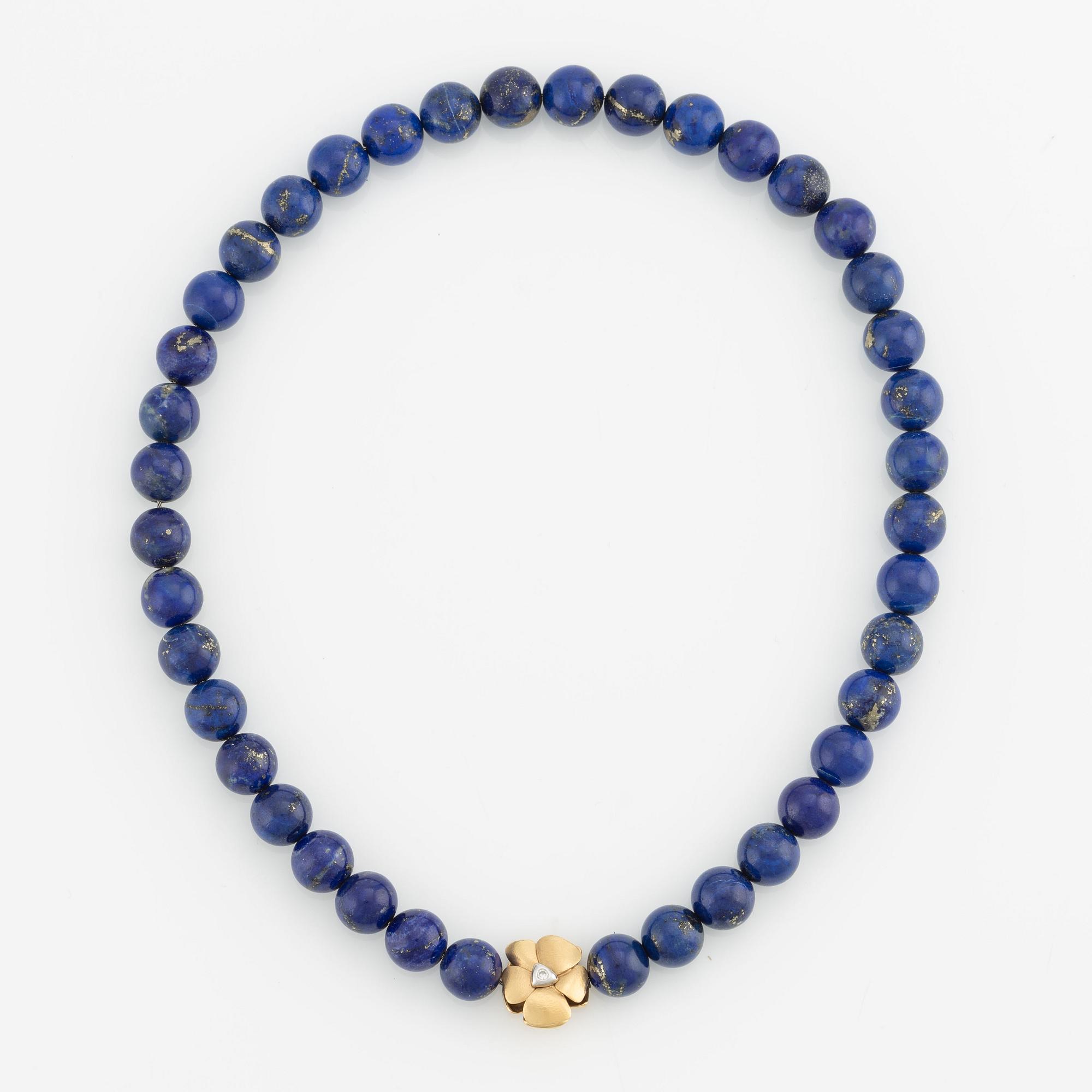 An Ole Lynggaard clasp in 18K gold with round brilliant-cut diamonds and a lapis lazuli necklace.