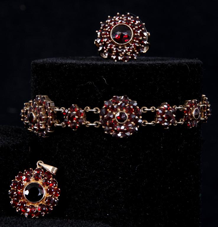 ARMBAND, HÄNGE SAMT RING, förgyllt silver samt granater. 1900-talets början.