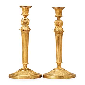1463. A pair of French Empire early 19th century gilt bronze candlesticks.