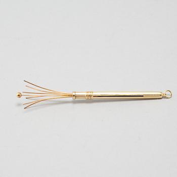 An 18k gold champagne whisk.