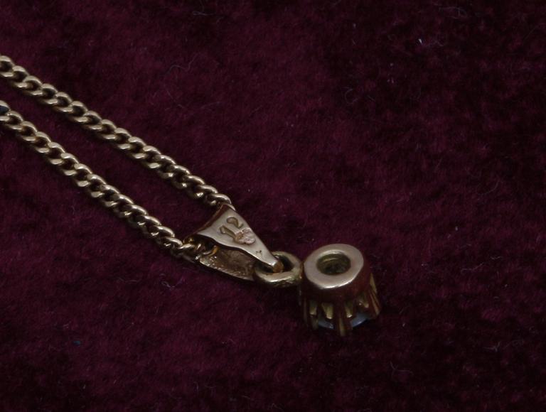 HÄNGSMYCKE. 18k guld med diamant, 0.12 ct enl gravyr.