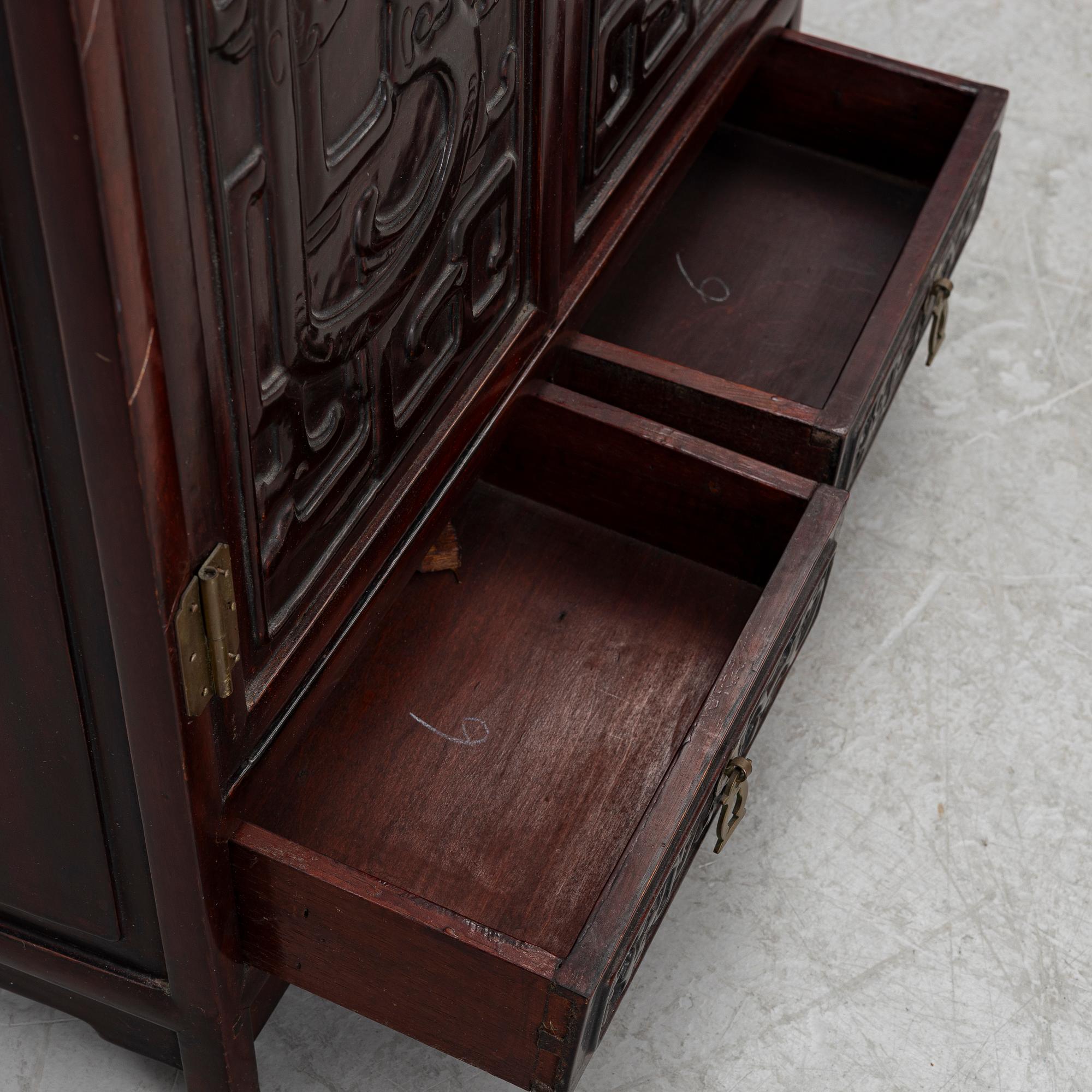 A small Chinese stained wood two part cabinet, 1900s.