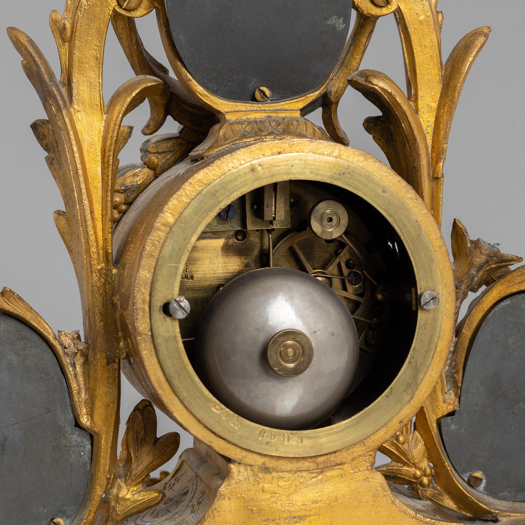 A Louis XVI style mantel clock and a pair of candelabra, circa 1900.