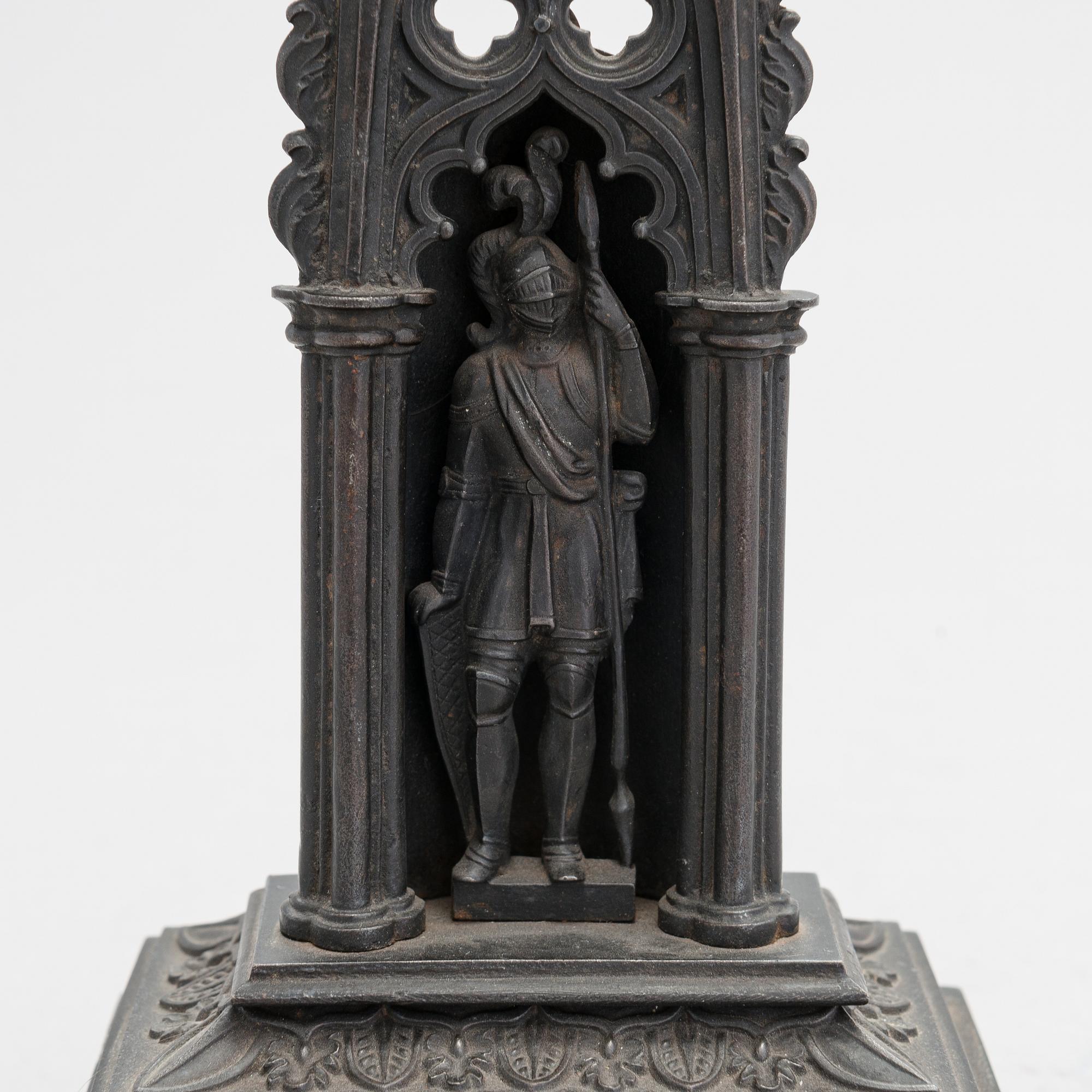 A neo-gothic cast iron pocket watch stand with a pocket watch. 19th century.