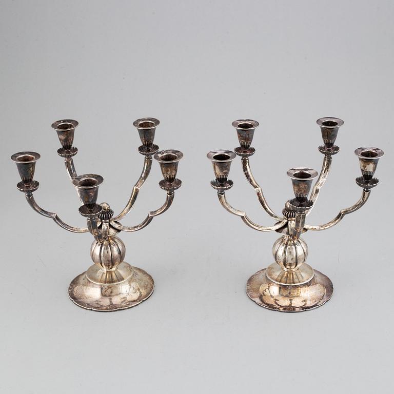 A pair of Swedish Grace silver candelbar for        five candles, mark of GAB, Stockholm, 1929.