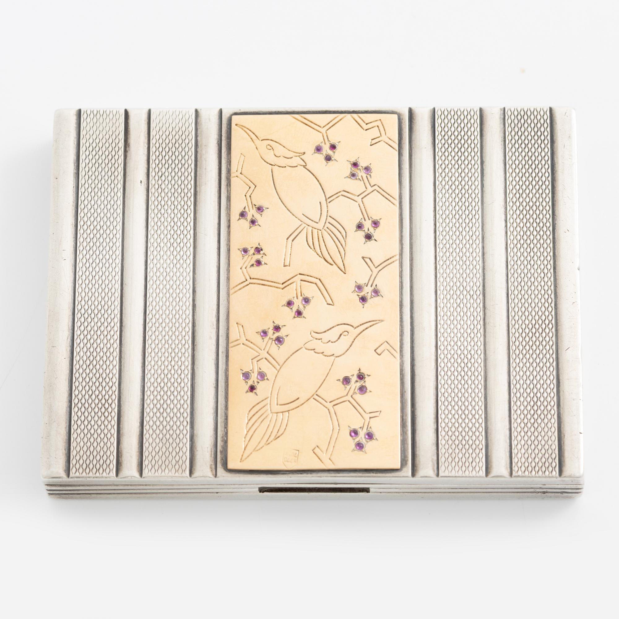 Puderdosa, silver samt guld. Med dekor av fåglar och rosa stenar.