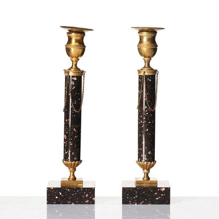 A pair of late Gustavian porphyry and gilt brass candlesticks, circa 1800.