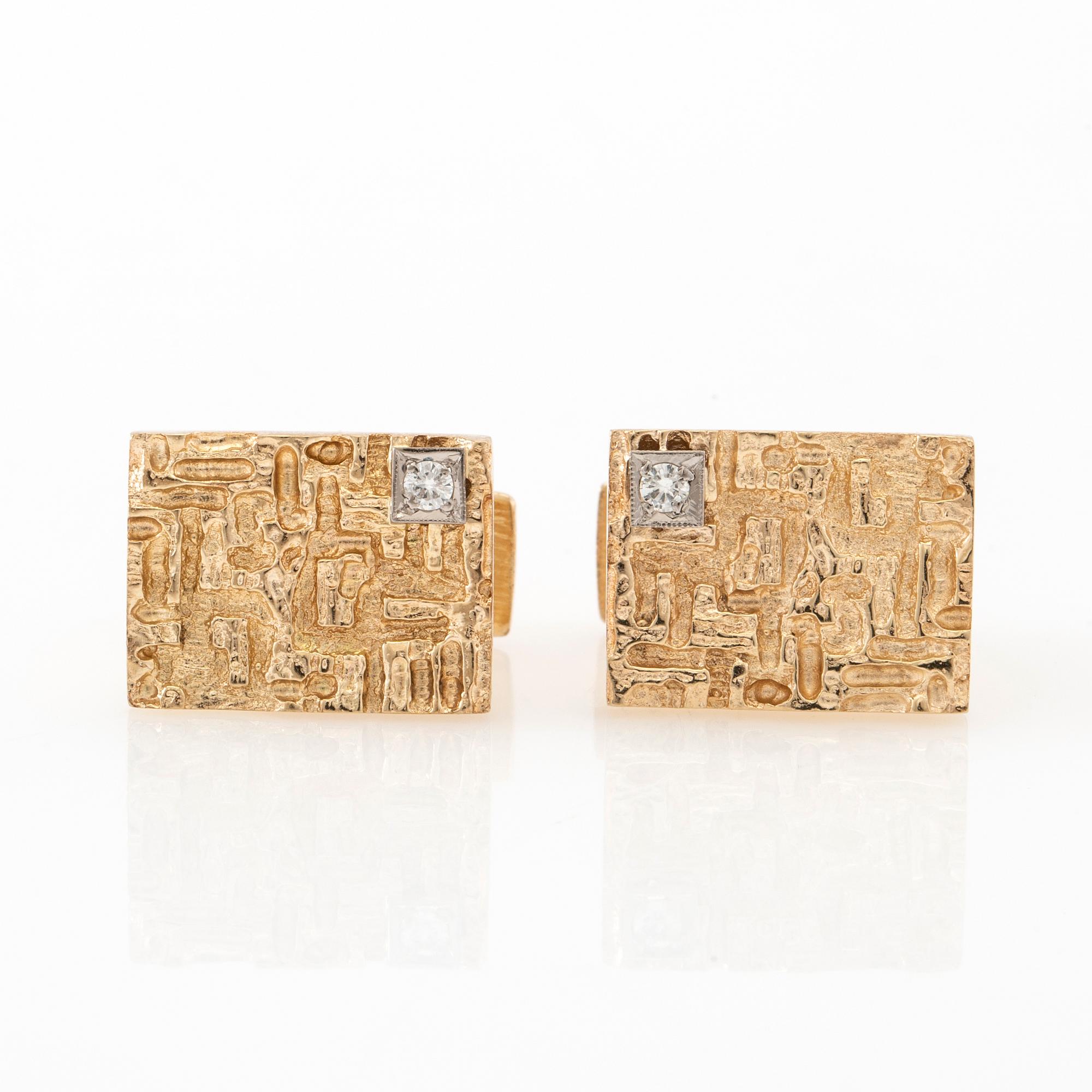 Manschettknappar ett par 14K guld med runda briljantslipade diamanter.