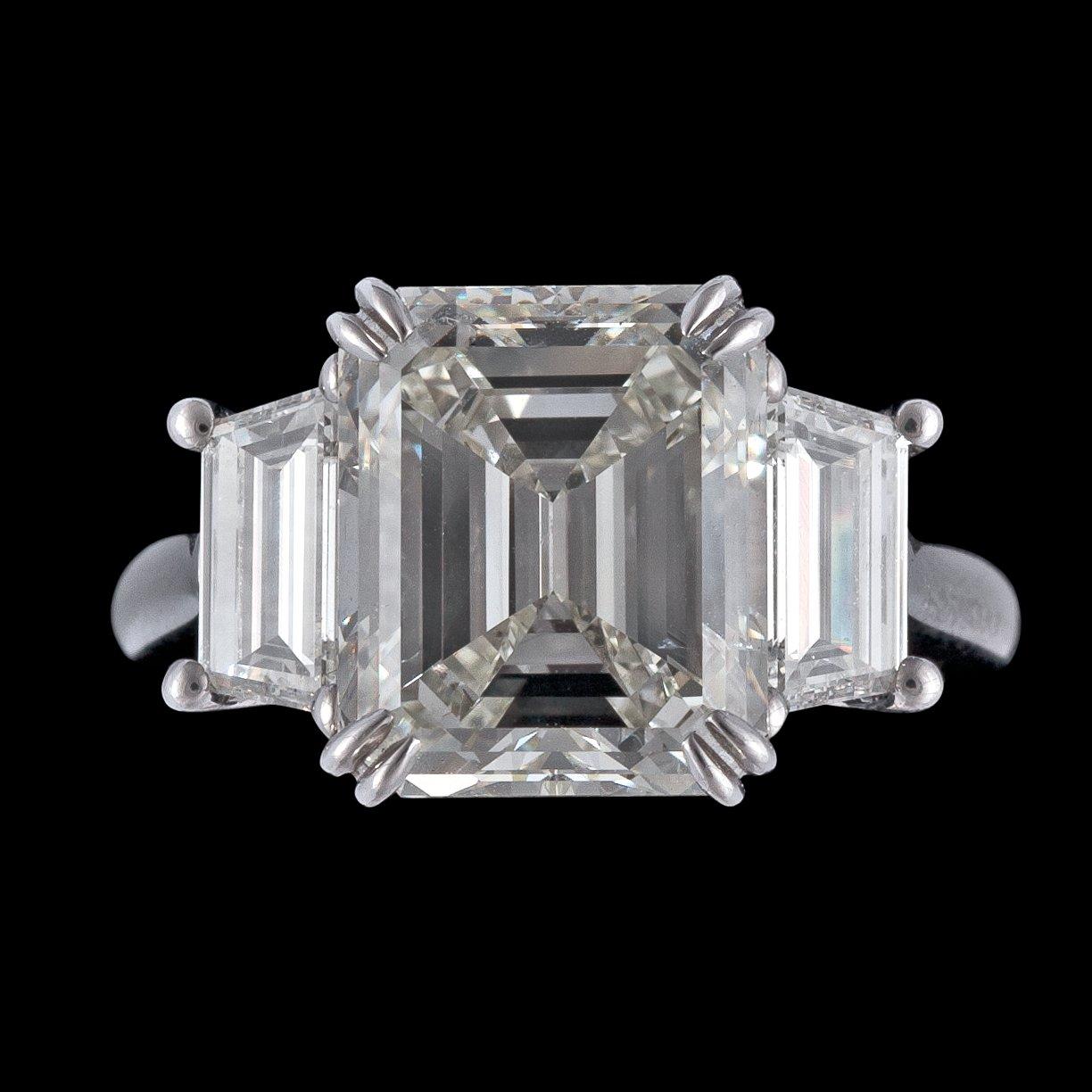 RING, smaragdslipad diamant, 6.27 ct samt mindre smaragdslipade diamanter på vardera sida.