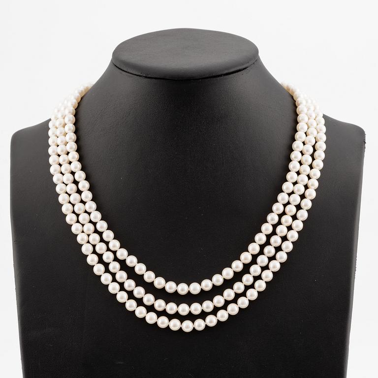 Necklace, pearls, three strands, clasp in 14K white gold with small diamonds.